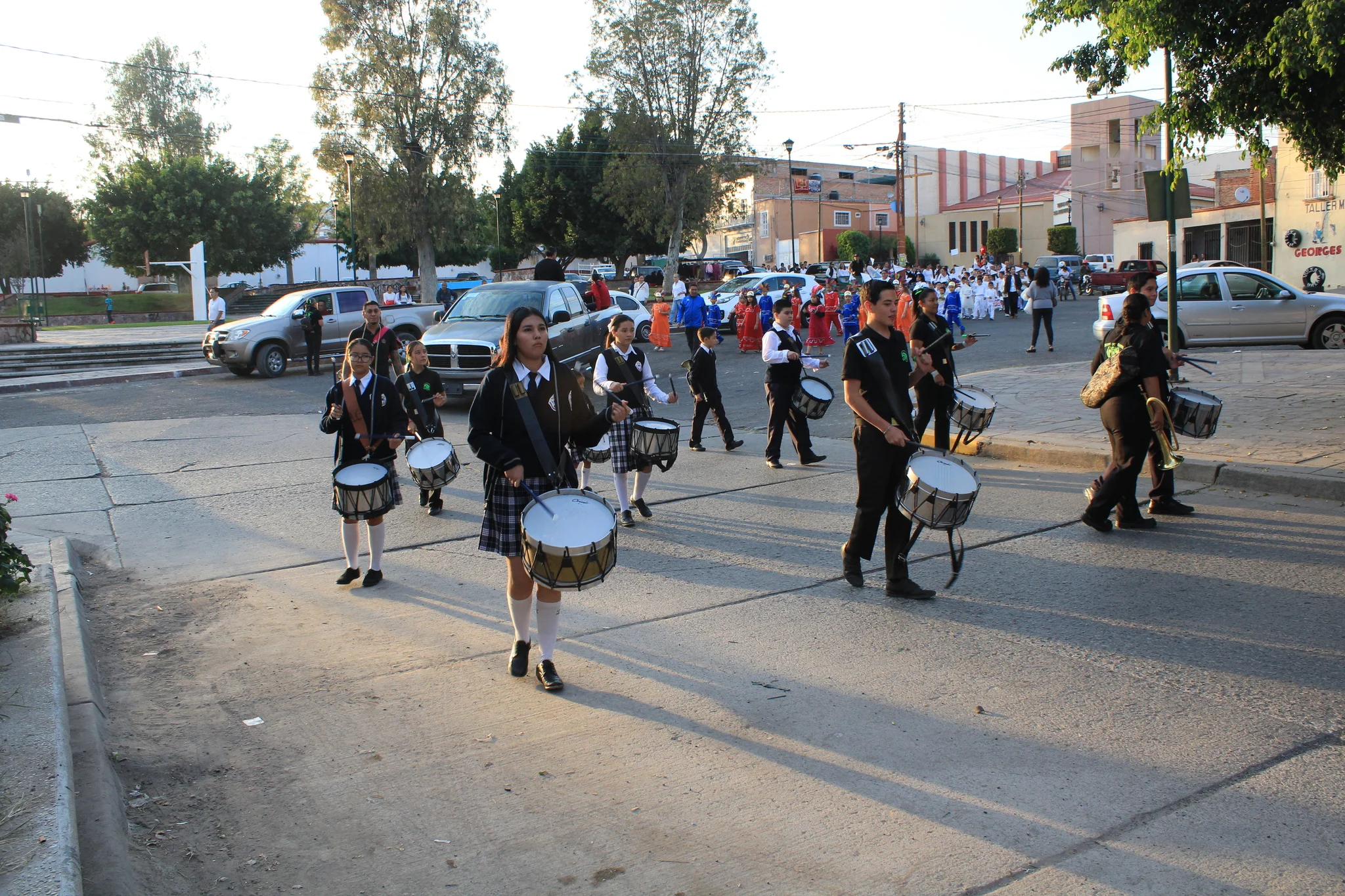 Integrantes de la banda de guerra del colegio marchan tocando sus tambores.